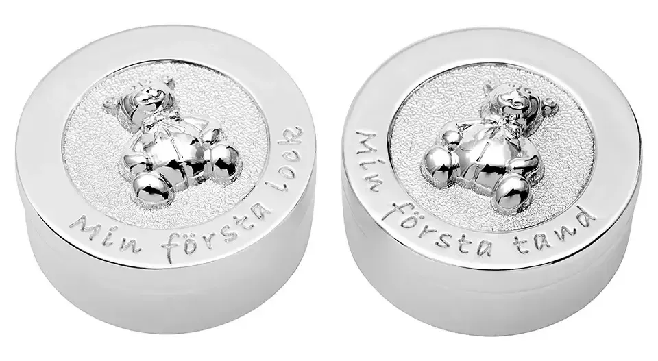 Fina silveraskar för första tand och hårlock.