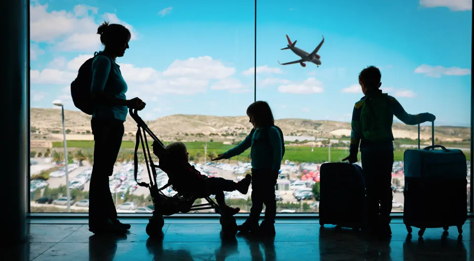 Här ser vi en familj med tre barn och en mamma som är på en flygplats och som ska ut och flyga.