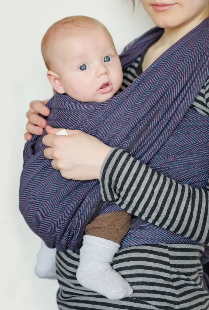 Ett exempel på en vävd bärsjal. Här med en vaken bebis som tittar in i kameran.